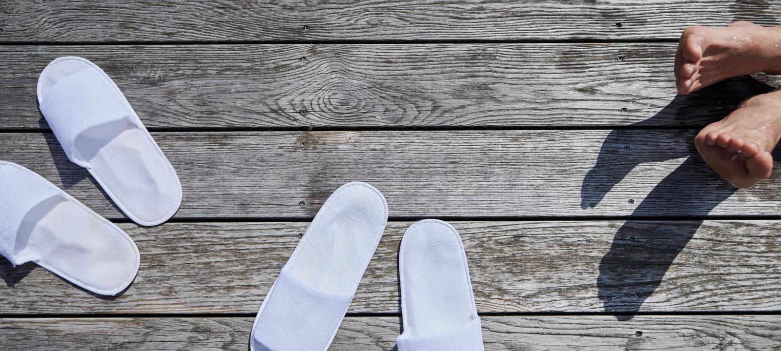 Badeschlappen auf dem Holzsteg am Naturteich Panoramaquell